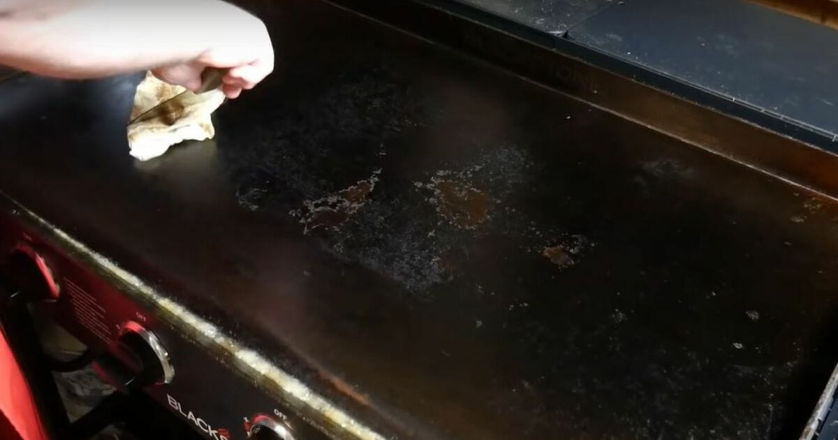 man hand cleaning blackstone griddle
