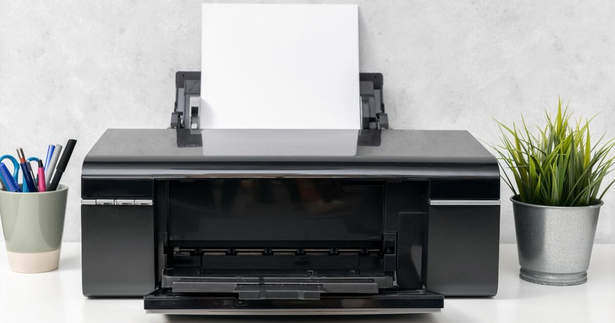 inkjet printer with blank paper sheet on office desk